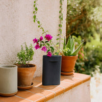 Black rectangular ceramic vase with vertical ribbed texture displayed on white background for modern home decoration.
