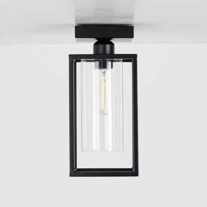 Black metal outdoor ceiling light with clear glass shade displayed with lights off on a clean white background showcasing its modern rectangular frame.