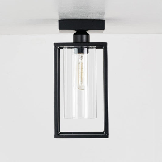 Black metal outdoor ceiling light with clear glass shade displayed with lights off on a clean white background showcasing its modern rectangular frame.