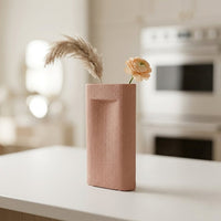 Pink ceramic flower vase with ribbed texture styled with dried blooms for elegant modern home decor placement.