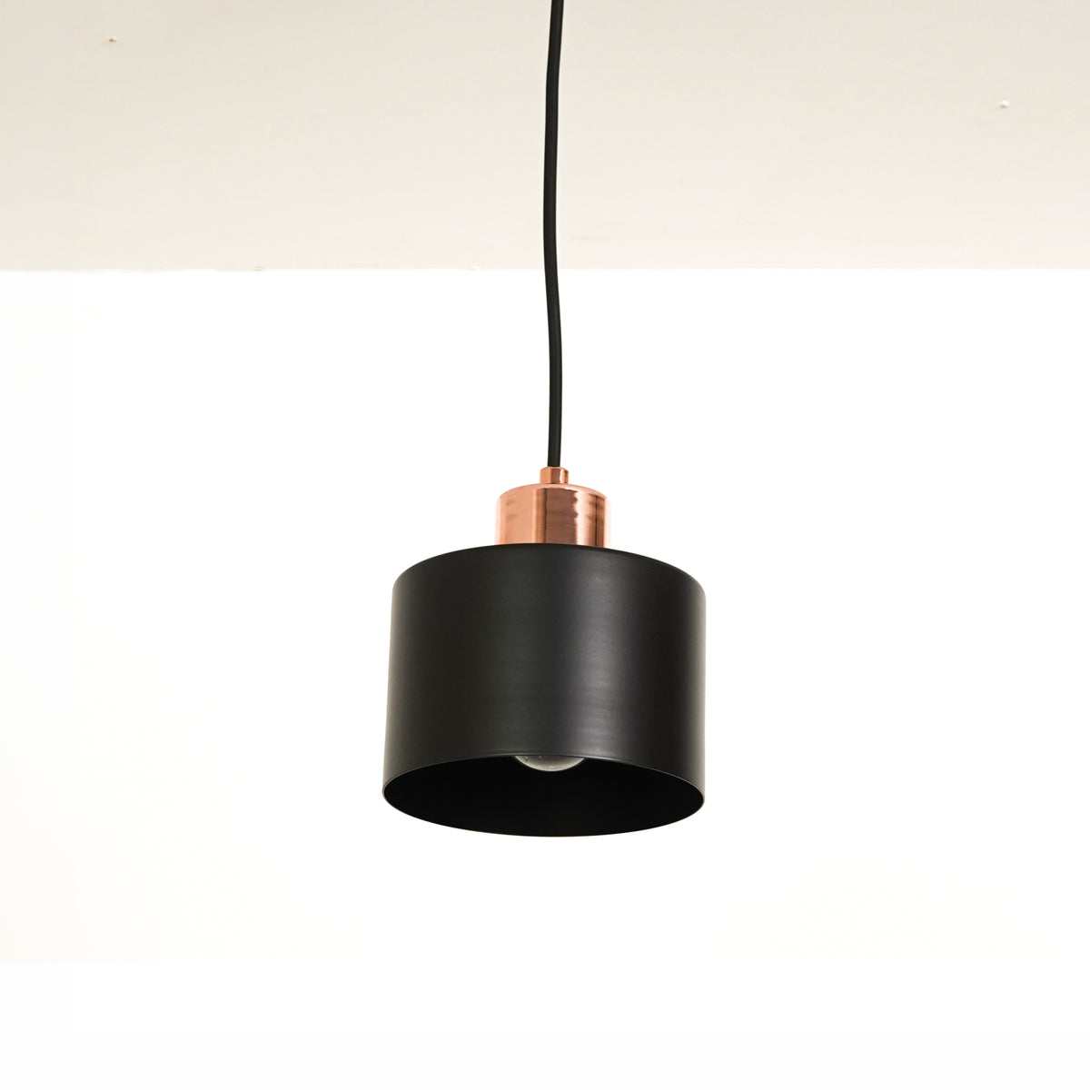 White background image of industrial black rose gold light for modern dining room decor styling with smooth matte finish.