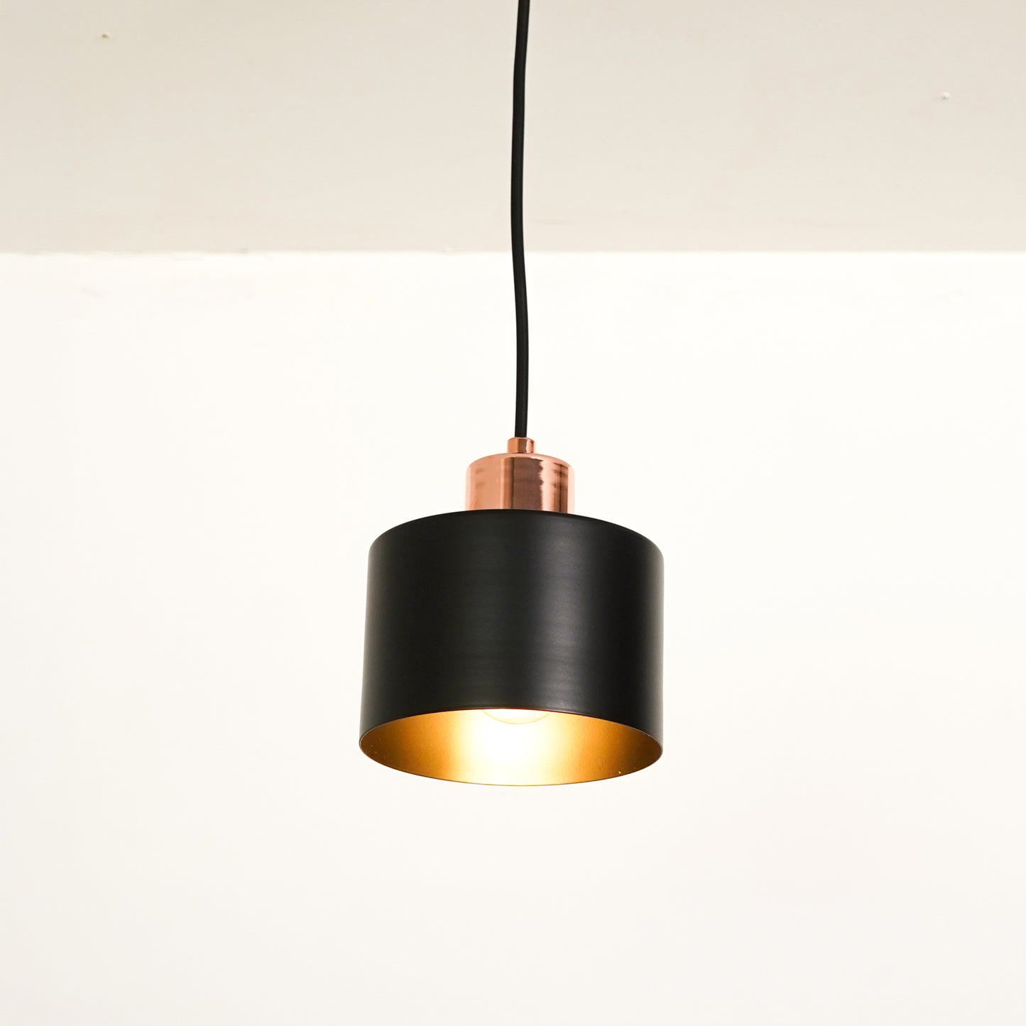 White background image of industrial black rose gold light for elegant dining room decor styling with bright illumination.
