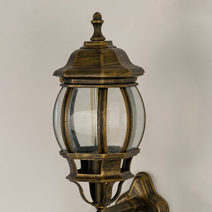 Closeup view of antique gold metal finish and intricate scroll details of the traditional outdoor wall lantern fixture.