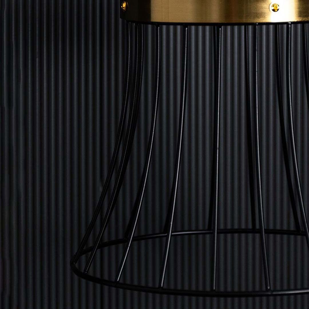 Closeup view of the black wire pendant light showing its warm glowing bulb and detailed curved metal frame design highlighted against a softly lit background.
