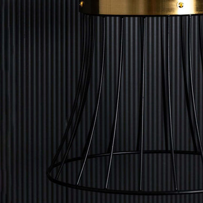Closeup view of the black wire pendant light showing its warm glowing bulb and detailed curved metal frame design highlighted against a softly lit background.