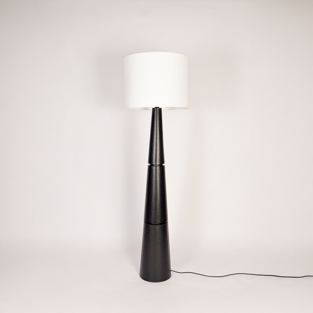 Floor lamp off on white background displaying tall textured black base with wide white drum shade for minimalist interior styling homes feel now.