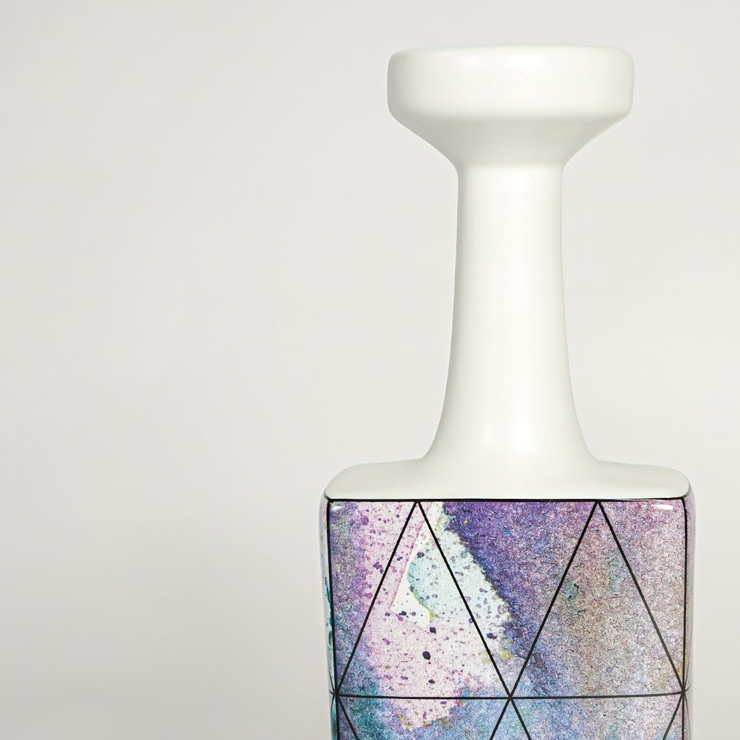 Closeup image of white ceramic bottle vase with purple abstract artwork for modern tabletop decor styling.