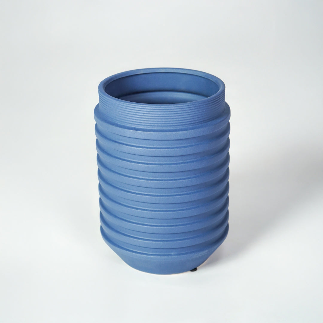 Blue ceramic ribbed planter vase for modern tabletop decor styling with elegant matte finish on white background.