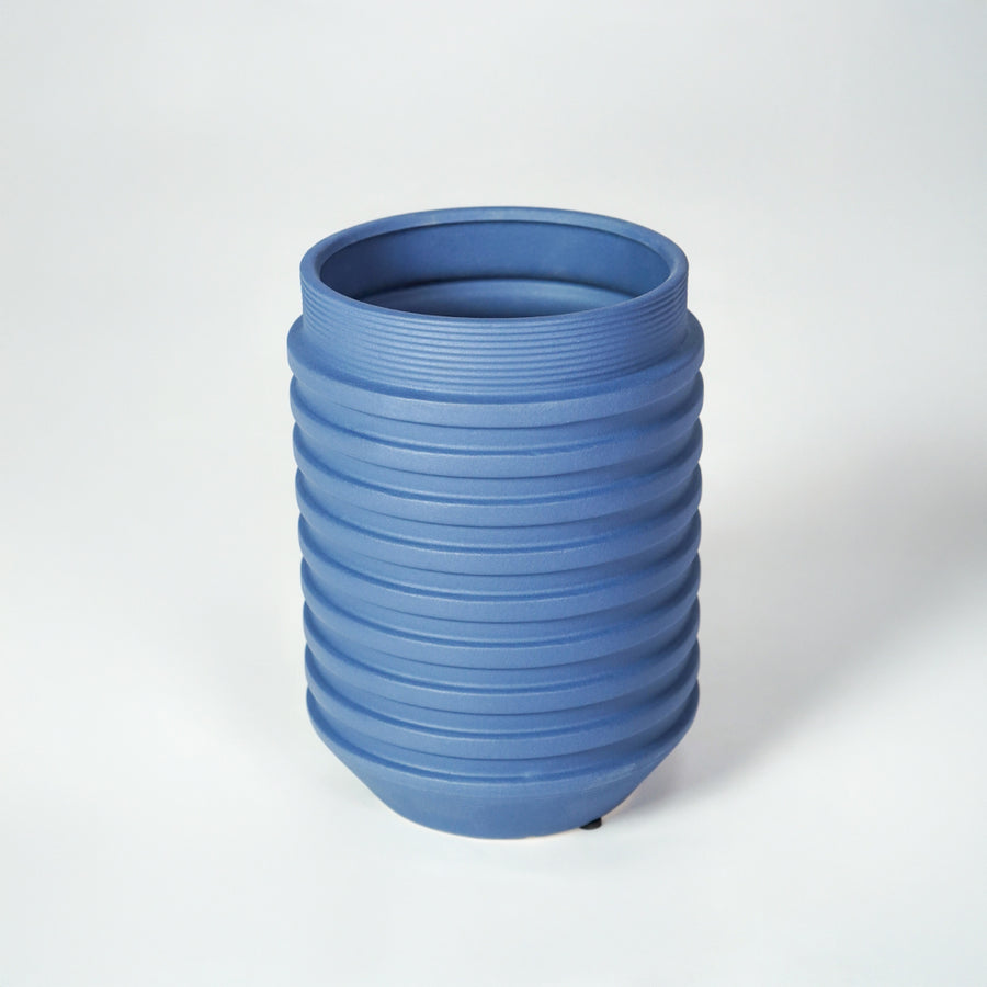 Blue ceramic ribbed planter vase for modern tabletop decor styling with elegant matte finish on white background.
