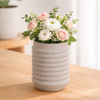 Beige ceramic flower vase with ribbed texture styled with fresh blooms for elegant modern home decor placement.