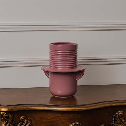 Modern pink ceramic vase with ribbed detailing perfect for displaying fresh or dried flowers in elegant home decor.