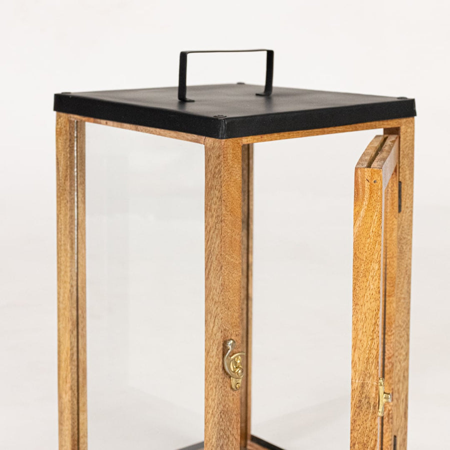 Closeup of wood and metal lantern top highlighting black metal lid handle detail and solid construction for decor lighting.