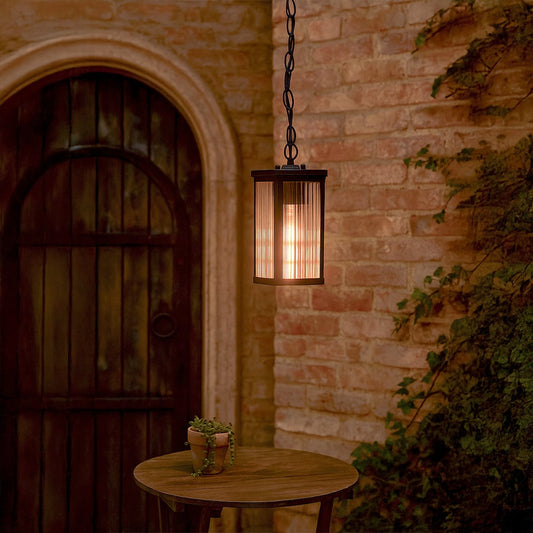 Elegant black metal hanging lantern with ribbed glass adding warm ambient lighting for outdoor and indoor home spaces.