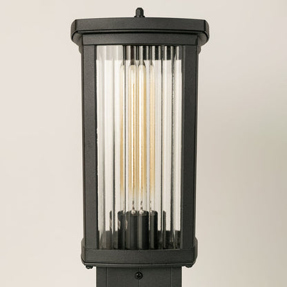 Closeup of black outdoor bollard light showing ribbed glass texture and modern clean structure ideal for pathway and garden lighting.