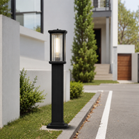 Contemporary black metal rectangular column bollard post light on driveway curb for modern residential estate path decor.