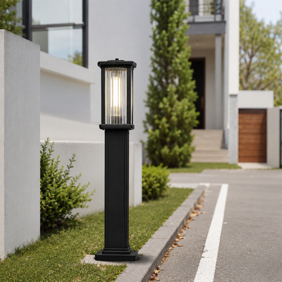 Contemporary black metal rectangular column bollard post light on driveway curb for modern residential estate path decor.
