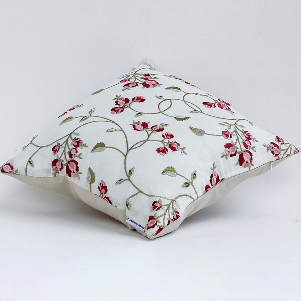 Side view of white cushion cover with red floral vine print soft fabric texture and elegant decorative sofa cushion styling.