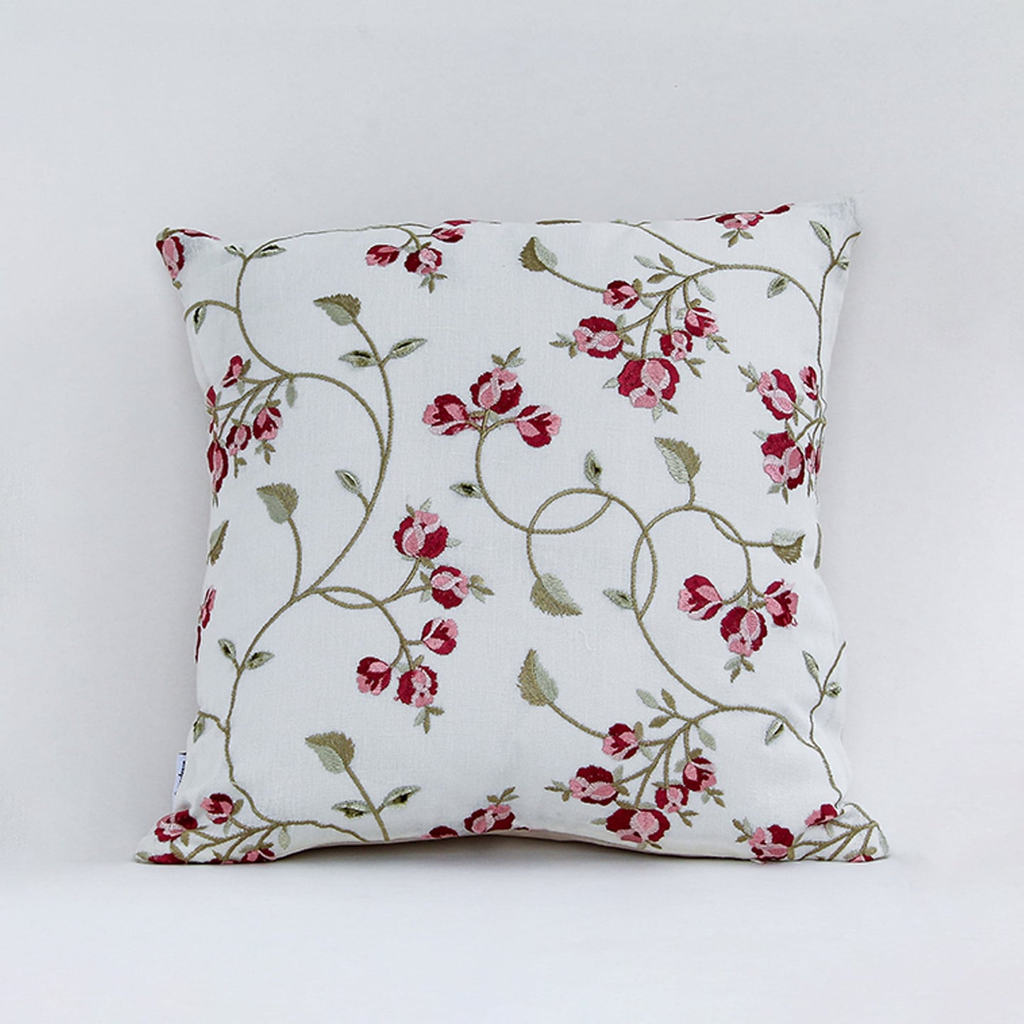 White cushion cover with red floral vine print on soft fabric designed for sofa chair and bed home decor styling.