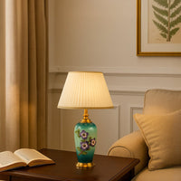 White shade floral ceramic table lamp on wooden side table with light on beside beige sofa for colorful decorative décor.