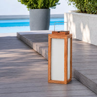 Modern copper metal outdoor lantern with clear glass panels creating warm decorative lighting for patios and garden spaces.