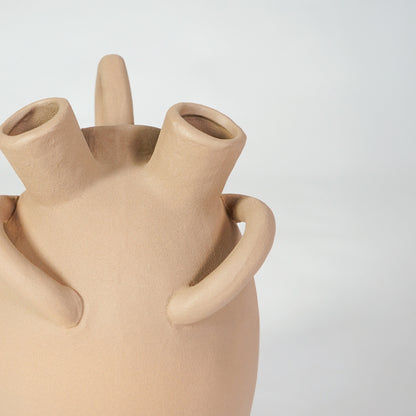 Closeup image of beige ceramic multi spout vase for modern tabletop decor styling with earthy matte finish.