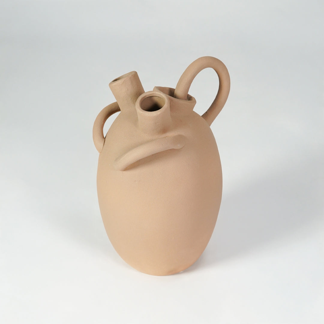 Beige ceramic vase with loop handles for stylish console table placement and contemporary indoor decor styling.