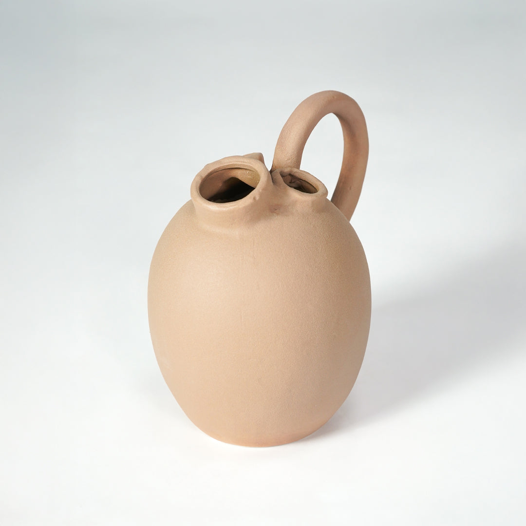 Beige ceramic vase with handle for stylish console table placement and contemporary indoor decor styling accent.