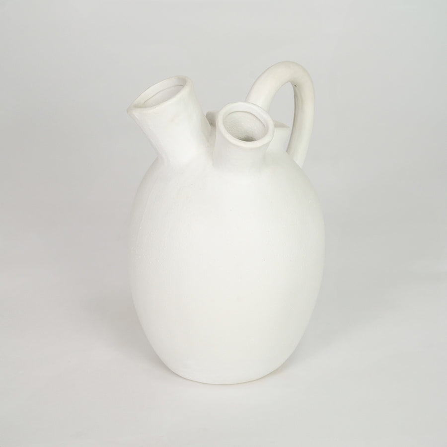 White ceramic vase with side handle for modern shelf placement and elegant indoor home decor styling accent.