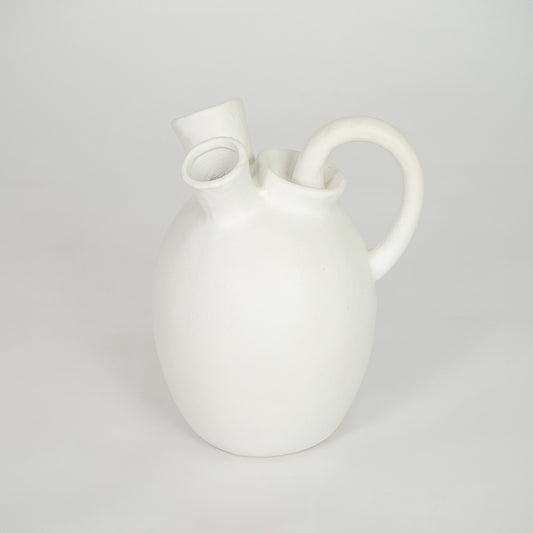 White ceramic vase with artistic handles for elegant coffee table placement and minimalist indoor decor styling.
