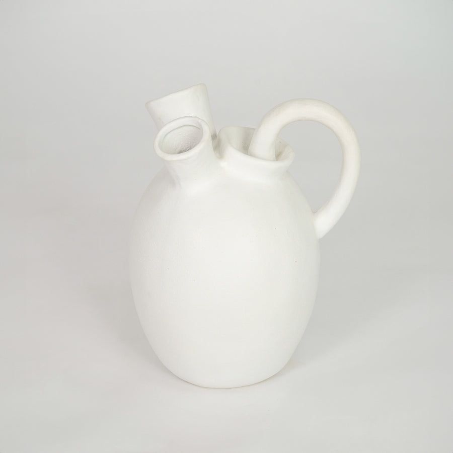 White ceramic vase with artistic handles for elegant coffee table placement and minimalist indoor decor styling.