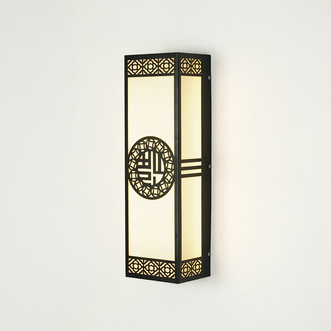 Decorative outdoor wall lantern with patterned metal frame and glass panels mounted on exterior wall ideal for porch or entry lighting.