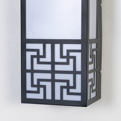 Closeup of black outdoor wall light featuring geometric cut metal frame frosted diffuser and modern architectural detailing.