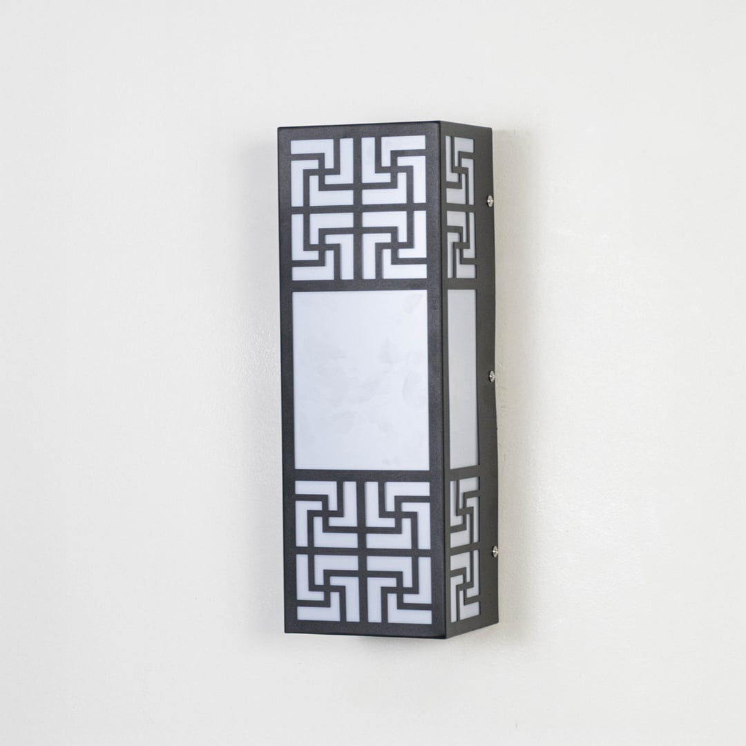 Stylish wall light with black metal body and frosted glass shade displayed off on plain white background.