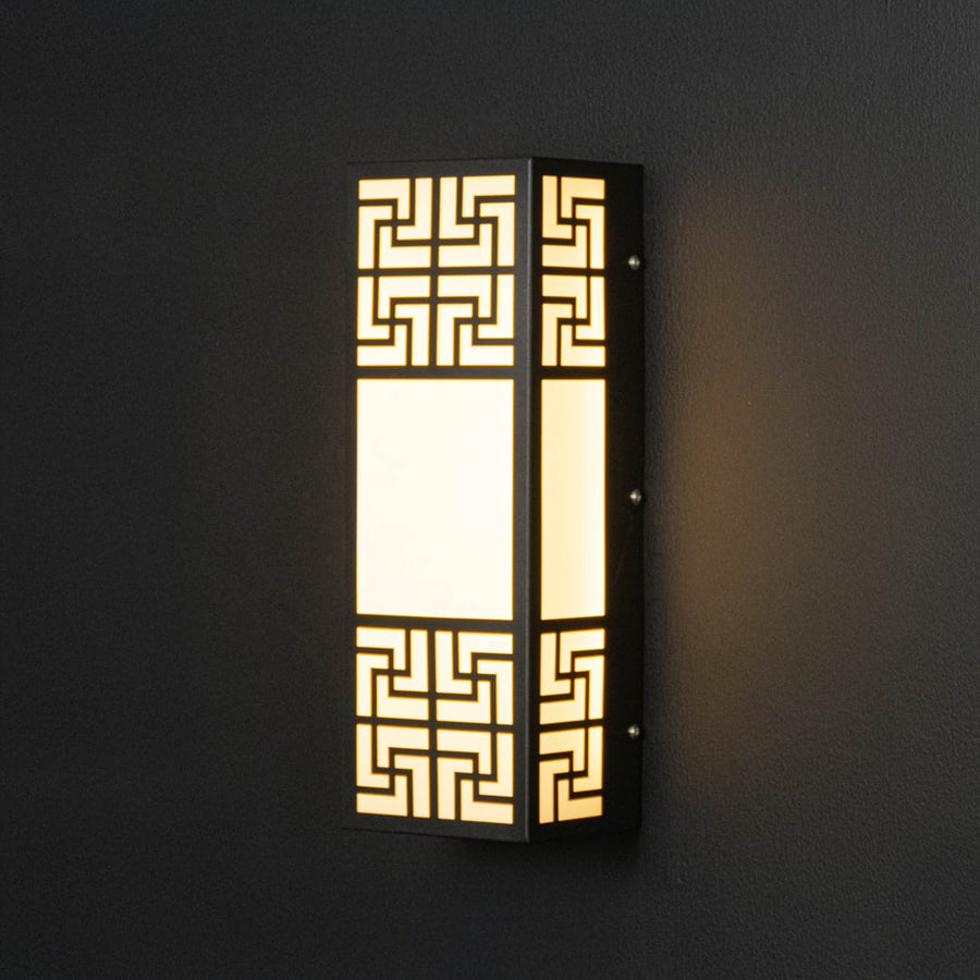 Black geometric wall light glowing warmly through frosted glass adding sophistication to modern wall spaces.