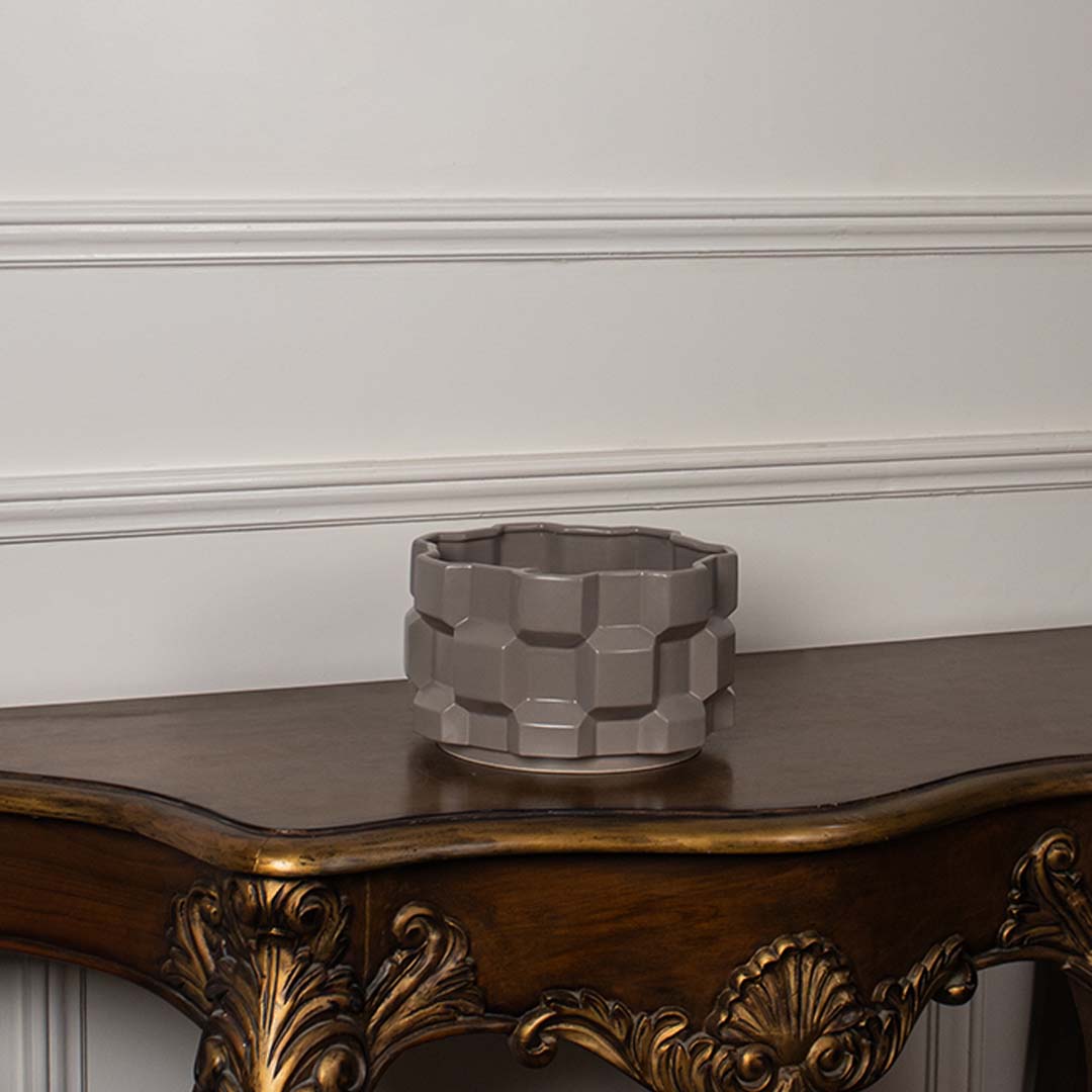 Taupe geometric ceramic planter displayed on a clean white background showing its shape and detailing clearly.