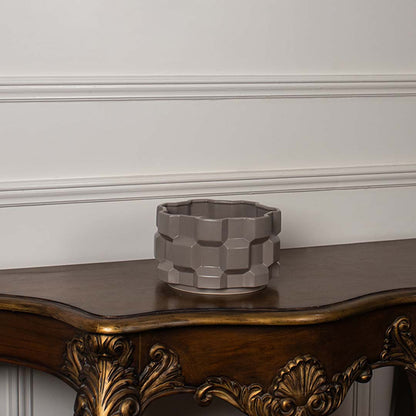 Taupe geometric ceramic planter displayed on a clean white background showing its shape and detailing clearly.
