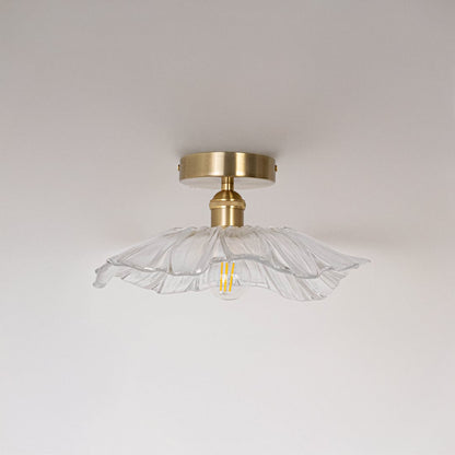 Ceiling light with brushed gold base and petal shaped glass shade shown switched off on plain white background.