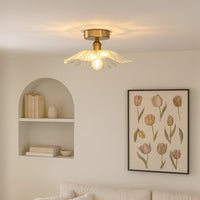 Modern ceiling light with brushed gold base and flower shaped glass shade styled in living room for elegant home lighting.