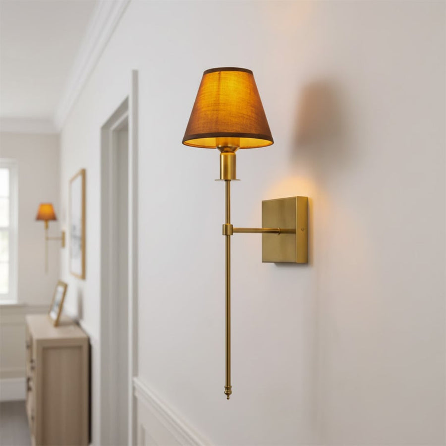 Gold metal wall light lifestyle image with warm fabric shade for elegant modern hallway interior decor.