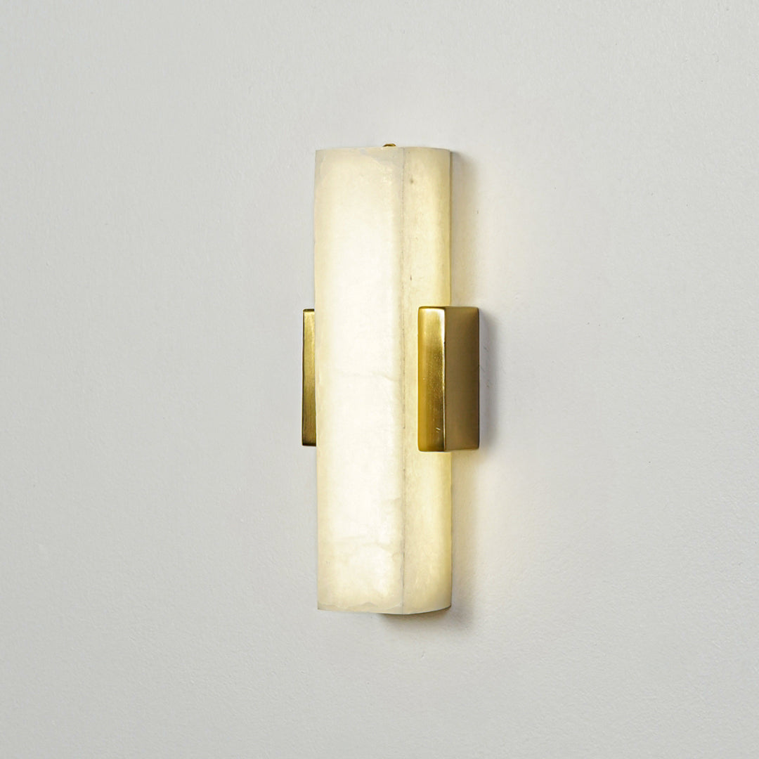 Gold wall sconce with cylindrical frosted glass shade mounted on neutral wall background perfect for modern bedroom or hallway lighting.

