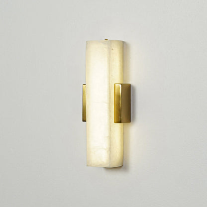 Gold wall sconce with cylindrical frosted glass shade mounted on neutral wall background perfect for modern bedroom or hallway lighting.

