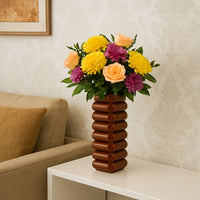 Decorative flower arrangement displayed in a textured vase bringing warmth color and artistic charm to a relaxed living room setting.