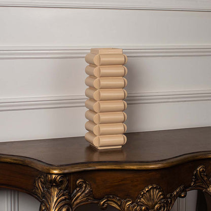 A beige geometric vase photographed on a clean white background showcasing its stacked rounded shape and contemporary decorative appeal.