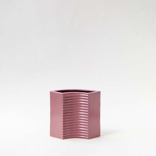 Dusty pink ceramic decorative vase with ribbed texture for tabletop styling and contemporary home decor displays.