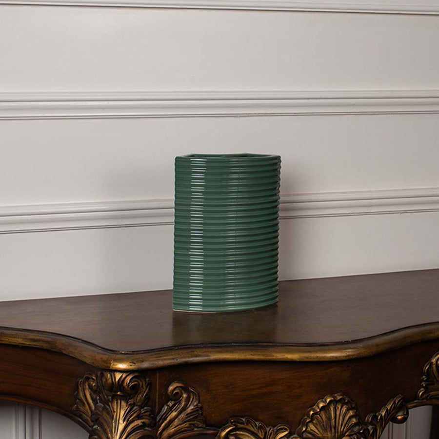 Dark green ribbed ceramic planter displayed on a clean white background ideal for sleek home decor and tabletop styling.