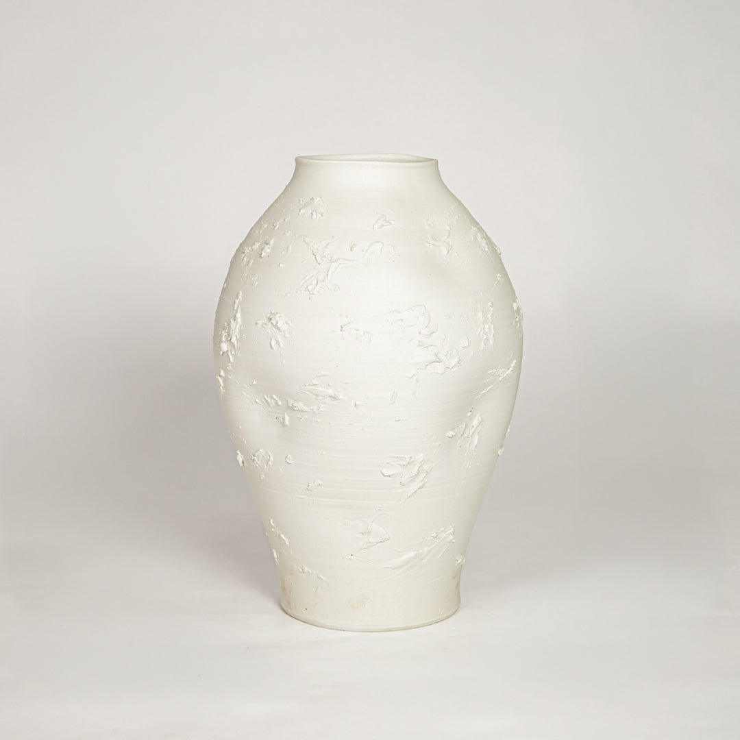 Sculptural white ceramic vase with organic shape for sophisticated modern home decor and minimalist interior style.