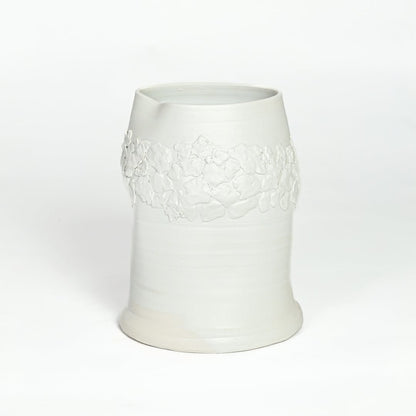 White ceramic decorative vase with embossed floral band isolated on white background for elegant tabletop decor placement.