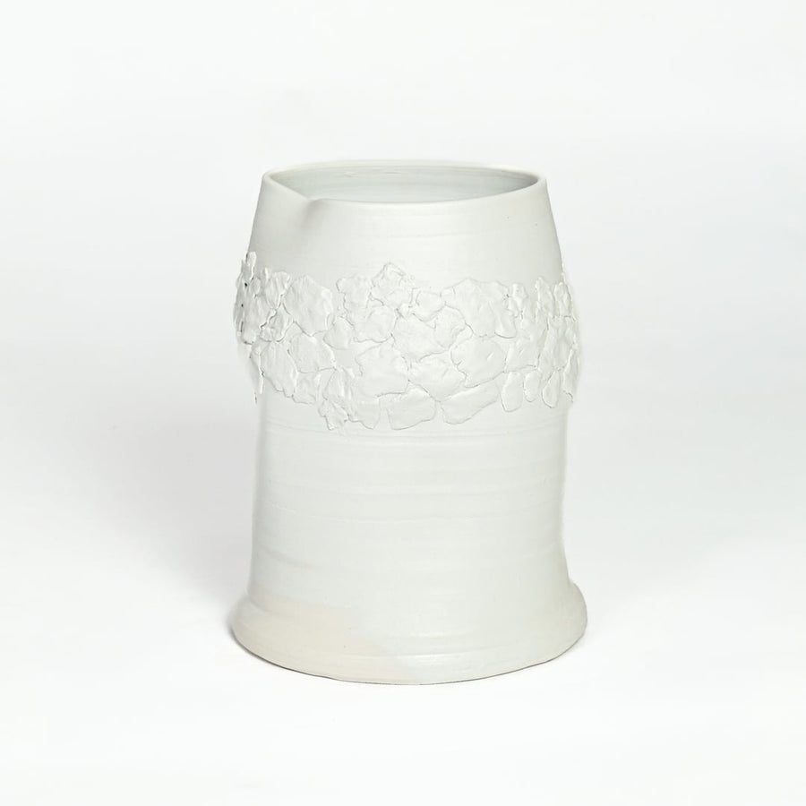 White ceramic decorative vase with embossed floral band isolated on white background for elegant tabletop decor placement.