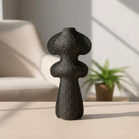 Black ceramic decorative vase styled on a side table creating an artistic focal point in modern home decor.