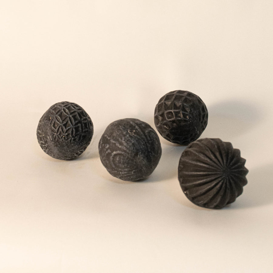 Decorative textured spheres in black finish with carved patterns for table decor or shelf styling modern home placement white background.